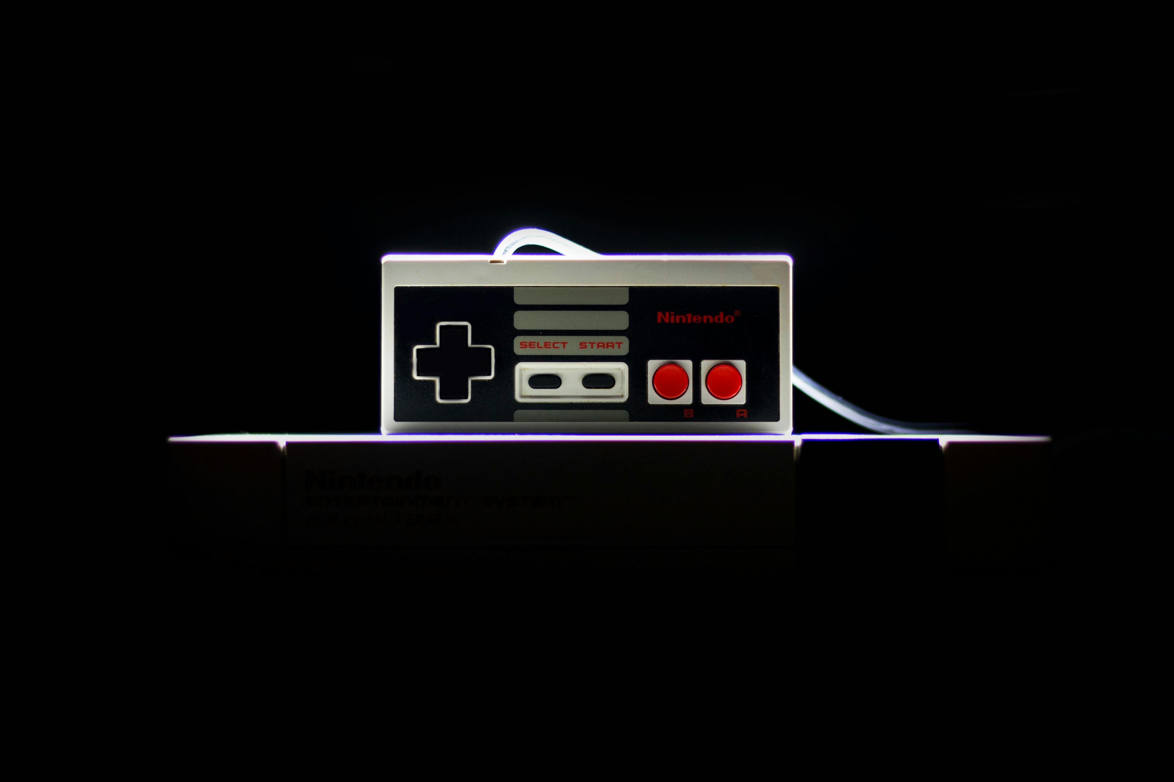 A close-up of a classic NES controller with dramatic lighting on a black background, evoking nostalgia.